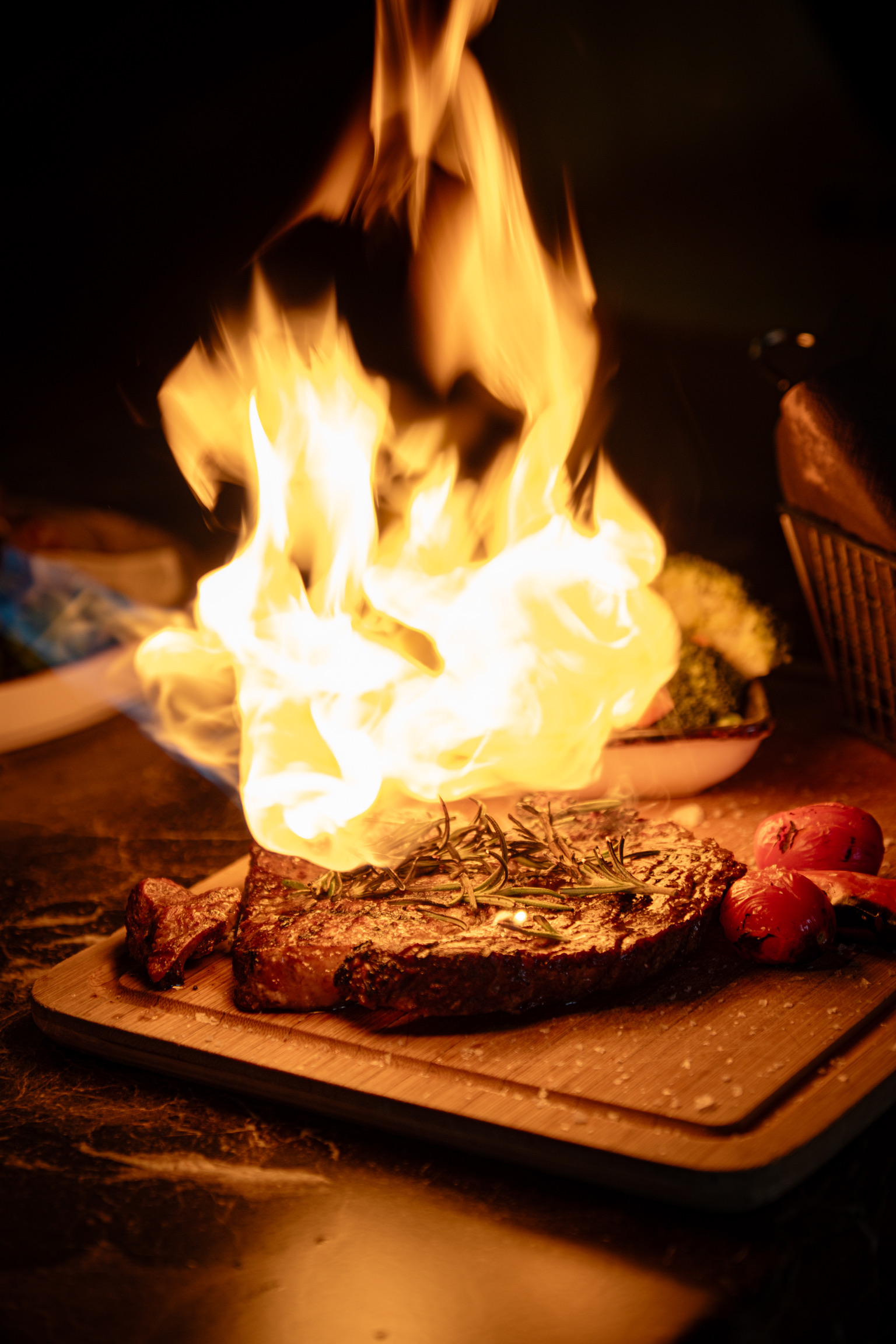 Flame-grilled steak presented with dramatic fire